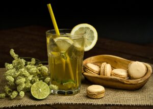 Tè freddo al limone e menta servito in un bicchiere con ghiaccio e fette di limone.
