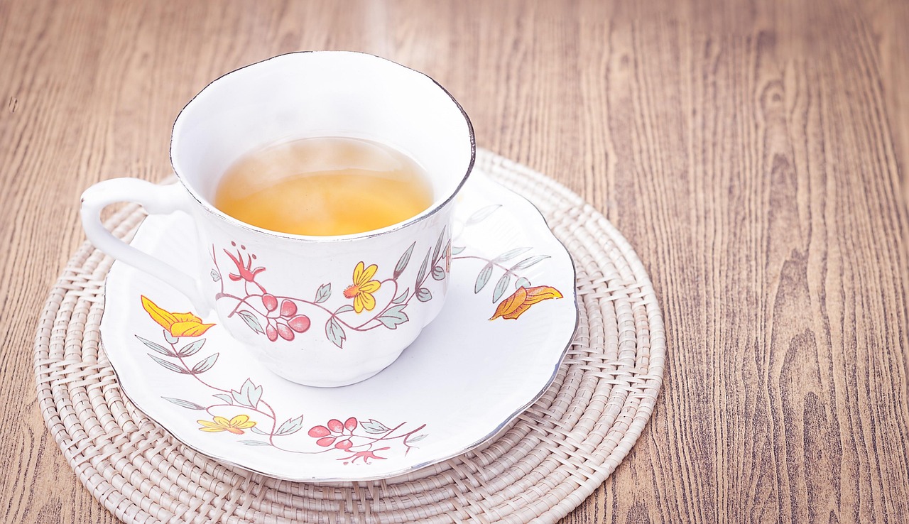 Tazza di tè verde fumante con foglie fresche, simbolo di accelerazione del metabolismo e perdita di peso.