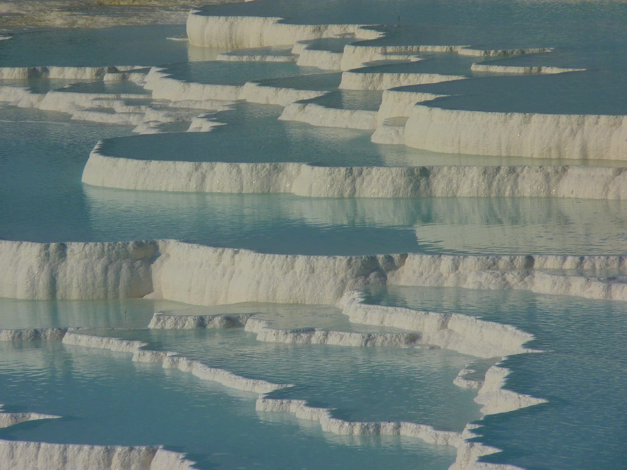 Sorgenti termali di Saturnia con acqua calda e paesaggio naturale circostante.