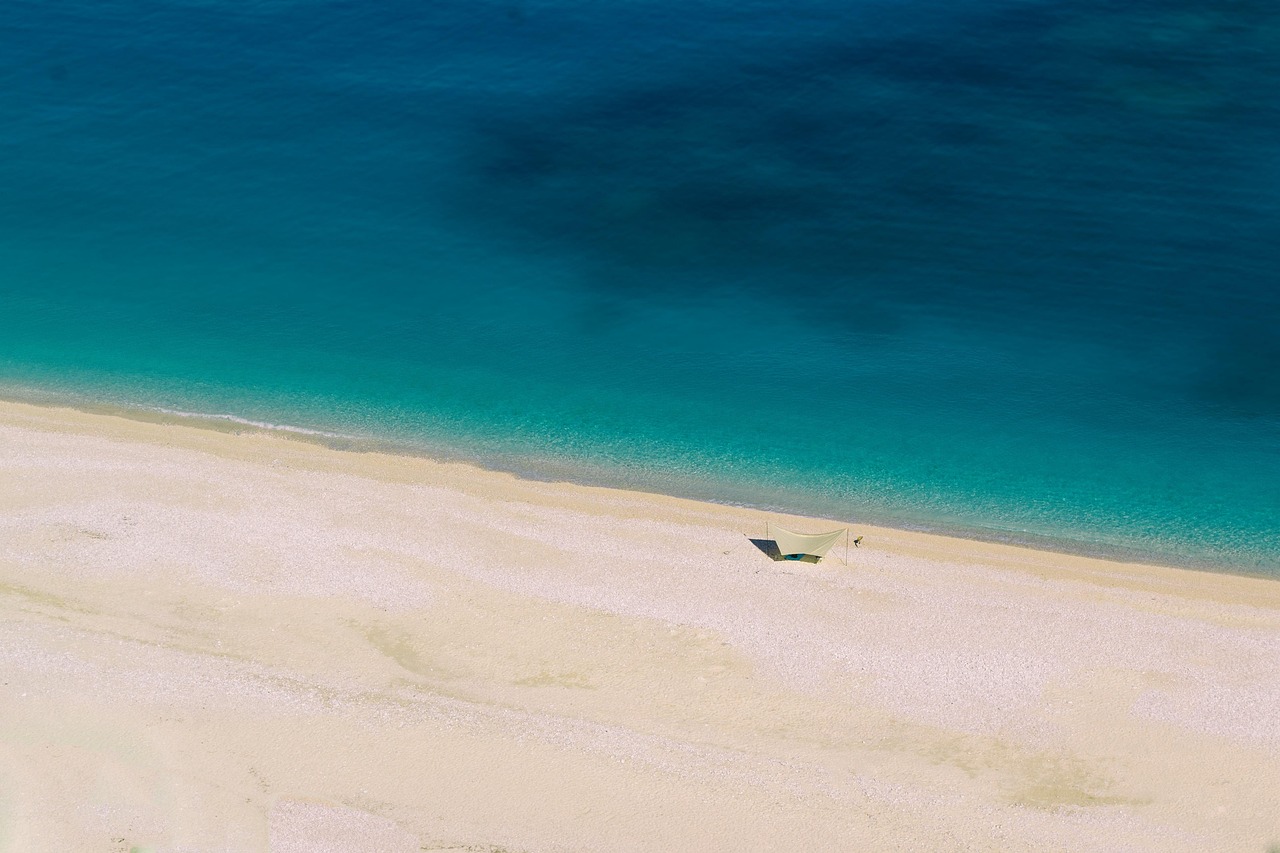 Spiaggia nascosta in Calabria con sabbia dorata e acque turchesi, ideale per rilassarsi.
