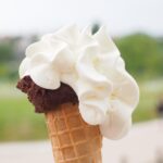 Gelato artigianale servito in un caratteristico comune ligure, con vista panoramica sul mare.