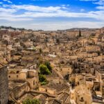 Panorama di una città italiana affascinante, con architettura storica e turisti entusiasti.