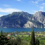 Lago italiano con acque turchesi e montagne sullo sfondo, simile a un fiordo norvegese.