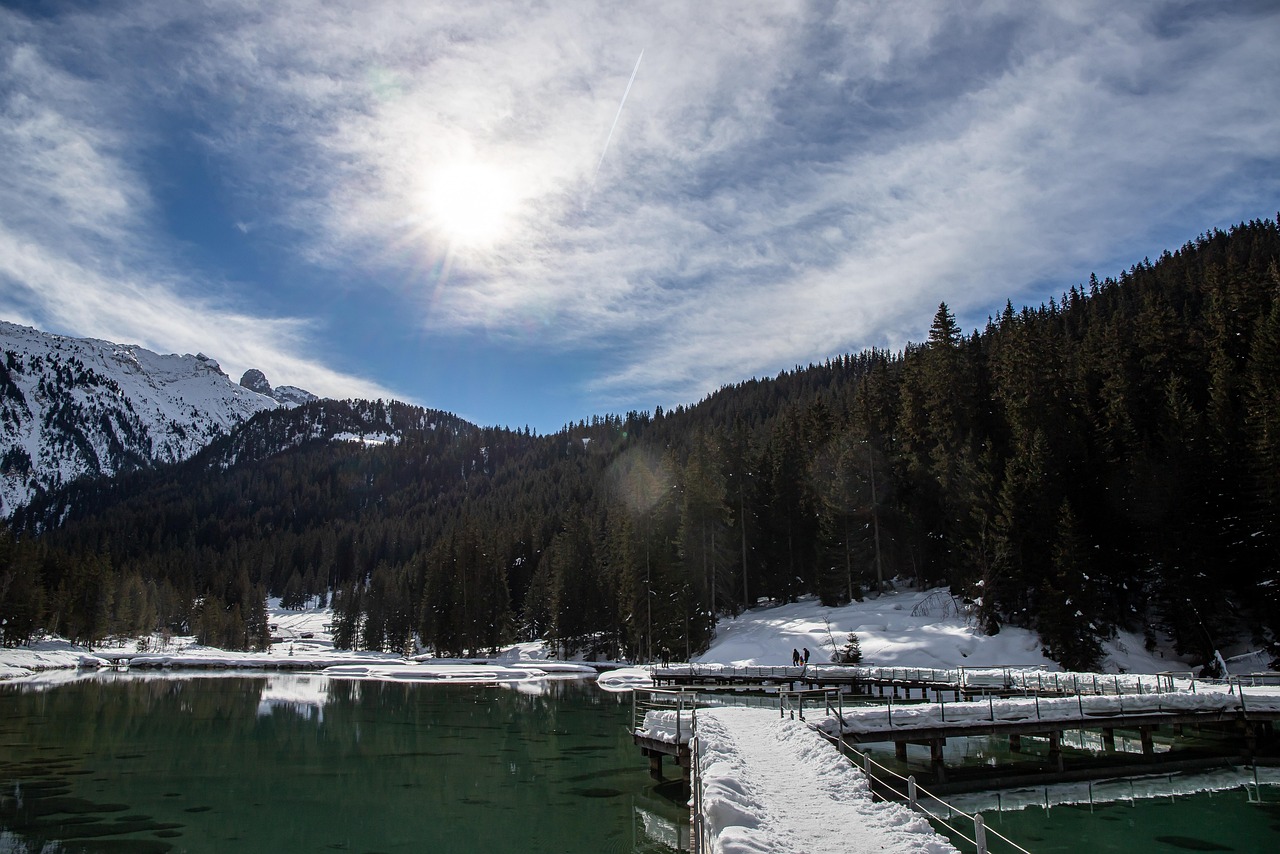 Lago di Carezza con il Latemar riflesso nell'acqua cristallina, circondato da boschi delle Dolomiti.