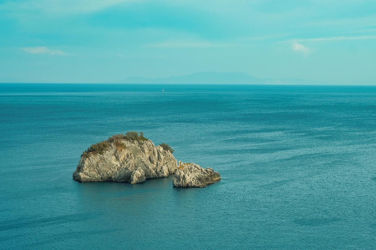Isola mediterranea con acque cristalline e blu intenso, ideale per una fuga estiva.